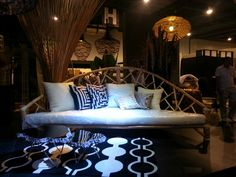 a living room filled with lots of furniture and pillows on top of a black floor