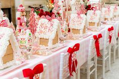 a table with gingerbread houses and candy canes on it for christmas dinner party