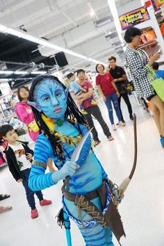 a woman dressed as avatar from avatar is holding a bow and looking at the camera