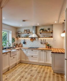 an open kitchen with white cabinets and wood flooring on the walls is pictured in this image