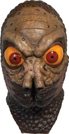 an alien creature mask with orange eyes and large, round red eyeballs on it's face