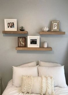 a bed with white linens and two wooden shelves above it