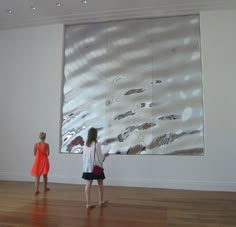 two women looking at artwork in an art gallery