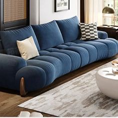 a living room with blue couches and white rugs on the wooden flooring