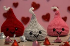 three crocheted pears sitting next to each other with hearts in the background