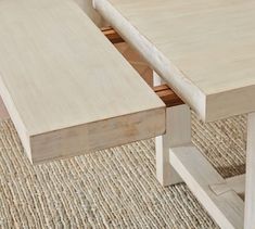 a close up of a wooden table with two drawers on it's sides and an area rug underneath