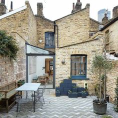 an outdoor patio area with brick walls and potted plants on the side of it