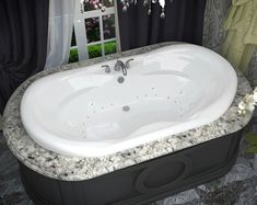 a large white bath tub sitting on top of a bathroom floor next to a window