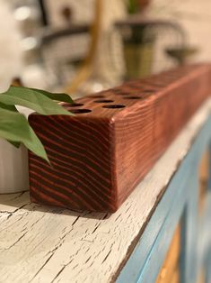 a close up of a wooden object with a plant in it's centerpiece