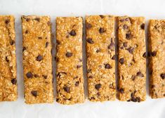 five granola bars lined up next to each other on top of a white surface