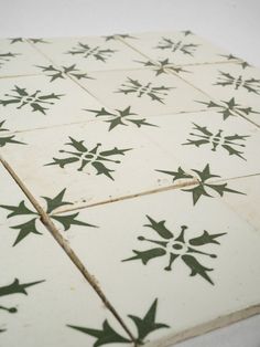 a white and green tile with black stars on it