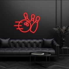 a living room with a black couch and blue neon bowling sticker on the wall