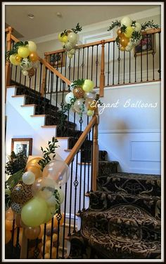 the staircase is decorated with balloons and greenery for an elegant touch to any home