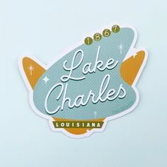 lake charles sticker on the side of a white wall with an orange and blue tail