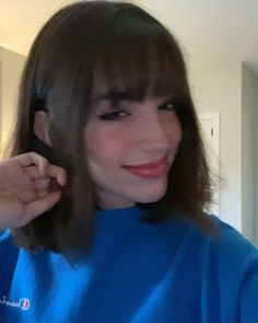 a woman in a blue shirt brushing her hair