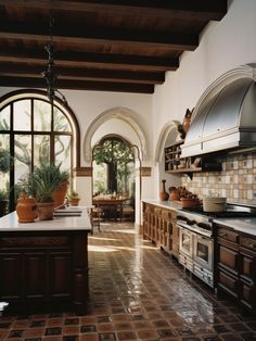 a large kitchen with an arched window and tile flooring