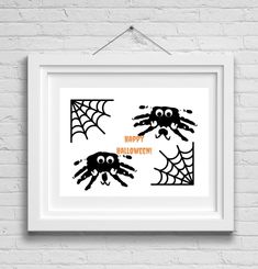 a white frame hanging on a brick wall with black spider webs and happy halloween lettering