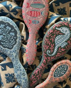 three decorative wooden spoons sitting on top of a blue and white cloth