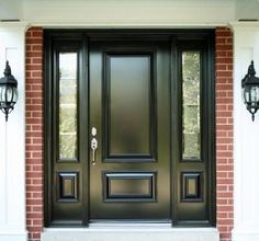 a black front door with two lights on either side and brick wall in the background