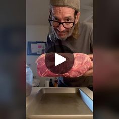 an old man holding up a raw piece of meat