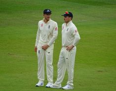 two men standing next to each other on a field