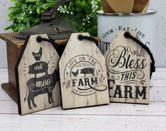 three wooden tags with farm sayings on them