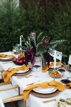 the table is set with plates and place settings