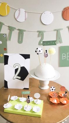 a table topped with cake and cupcakes covered in frosting next to paper decorations