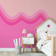 a bedroom with pink and white walls, wooden flooring and a small child's bed