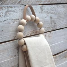 a wooden bead hanging on the side of a wall next to a napkin holder