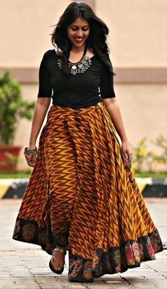 Vibrant orange and black combination ikat skirt with floor-length and traditional painted faces at the hemline Skirt And Top Indian, Long Skirt Top Designs, Simple Kurta, Long Skirt And Top, Kalamkari Dresses, Ikkat Dresses, Indian Skirt, Long Frock, Ikat Dress