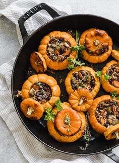 baked stuffed pumpkins in a skillet with herbs and nuts on the top, ready to be eaten