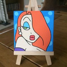 an easel with a painting of a woman's face on it