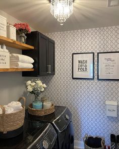 a washer and dryer in a room with pictures on the wall above it