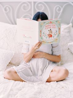 a woman reading a book on her bed with the caption, i love you