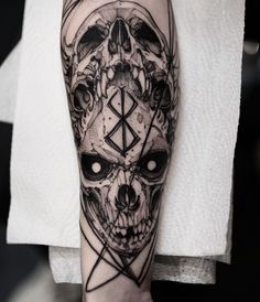 a man's arm with a skull and pentagramus tattoo design on it