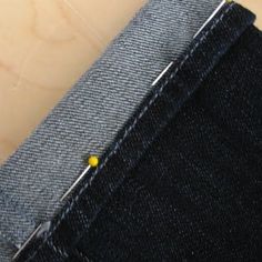 a pair of blue jeans with yellow pins sticking out of the back side of them