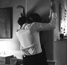 a man and woman are dancing in the living room with their arms around each other