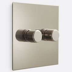 two round knobs on the side of a wall mounted light switch in stainless steel