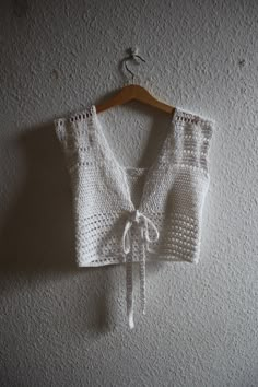 a crocheted crop top hanging on a wall