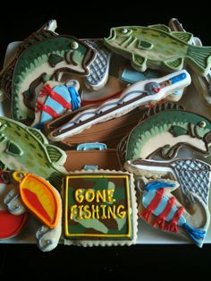 decorated cookies in the shape of fish and alligators with gone fishing written on them