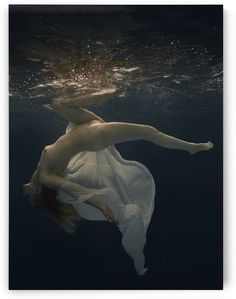 a woman in white dress floating under water