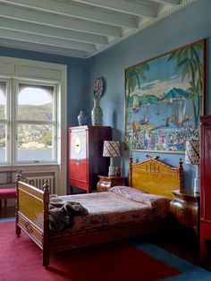 a bed room with a neatly made bed and a painting on the wall