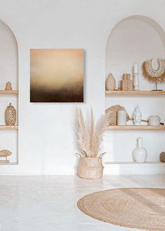 a living room with white walls and shelves filled with vases, plants and other items