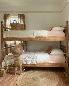 two bunk beds in a small room with baskets on the floor and one bed is made from wood