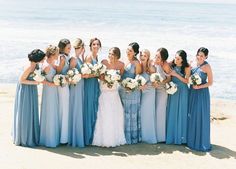 a group of women standing next to each other on top of a beach