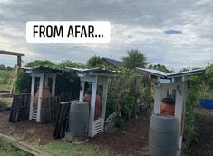 there are many small wooden outhouses in the yard with words from afar above them