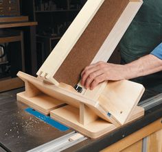 a person working on a piece of wood with a small device in the middle of it