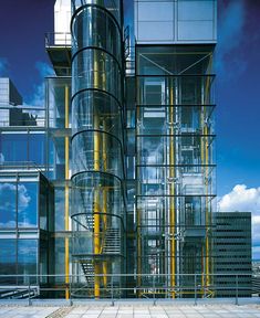 a tall building with lots of glass and yellow pipes