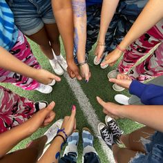 a group of people standing in a circle with their hands together